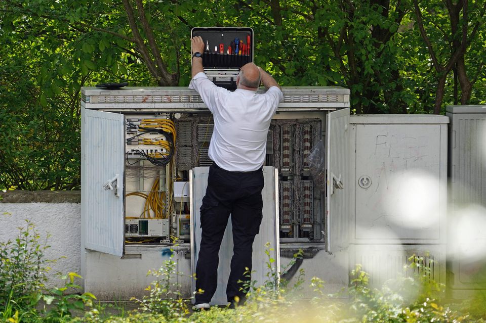 Ein Techniker der Deutschen Telekom an einem Telefonverteilerkasten