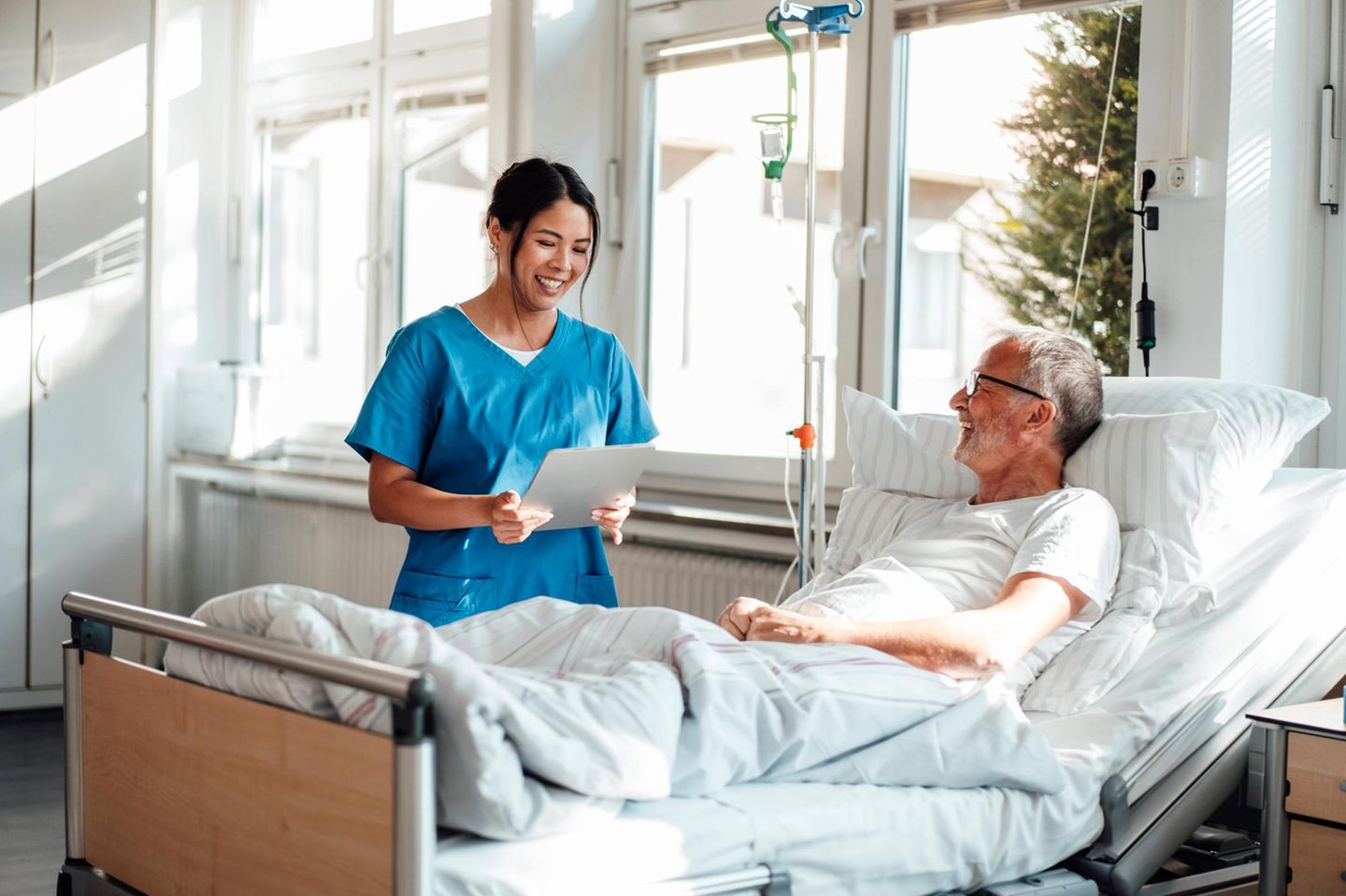 Krankenschwester, die einen Patienten in einem Krankenhauszimmer behandelt