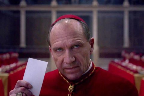 Ralph Fiennes spielt im Film einen Kardinal, der gerade einen Stimmzettel abgibt