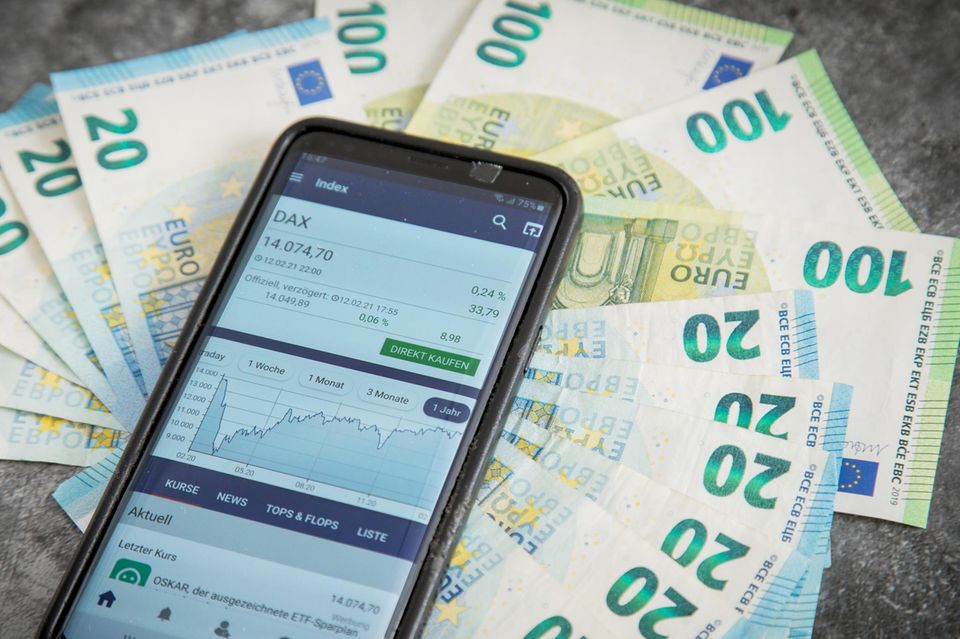 Geldscheine und Smartphone mit geöffneter Börsen-App