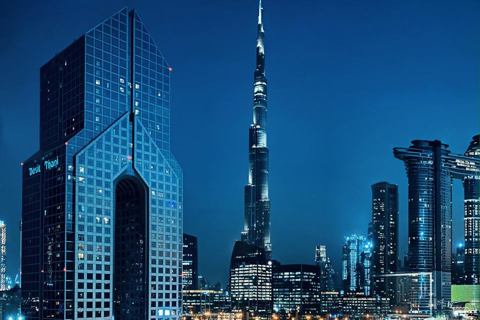 Das „Dusit Thani“ (l.) steht im Zentrum von Dubai, im Hintergrund sieht man das weltbekannte Gebäude Burj Khalifa aufragen