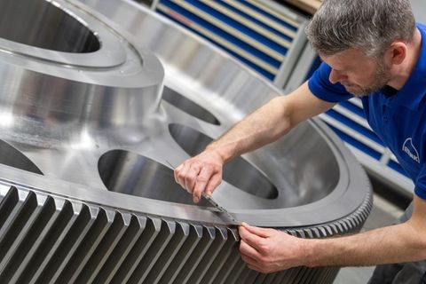 Ein Renk-Mitarbeiter kontrolliert ein Getriebezahnrad