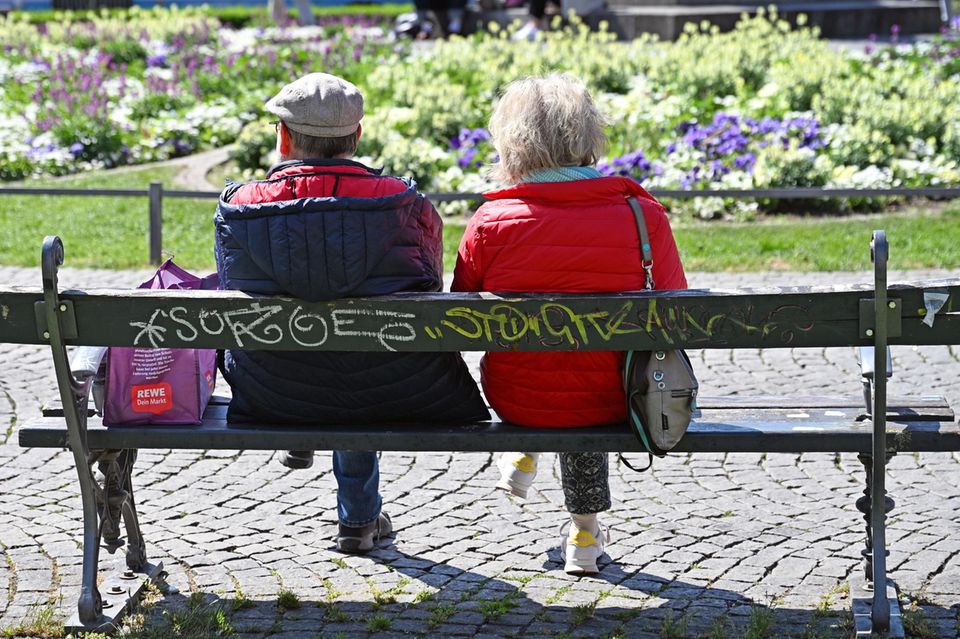 Ein äteres Ehepaar sitzt auf einer Bank