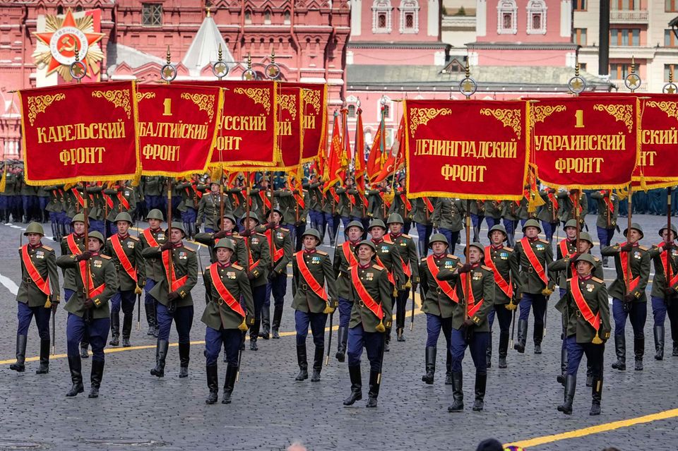 Russische Soldaten tragen bei einer Militärparade historische Fahnen