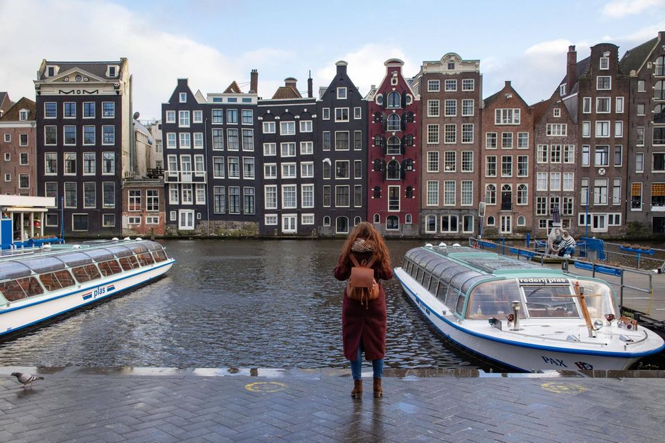 Frau macht ein Foto von den Häusern in Amsterdam