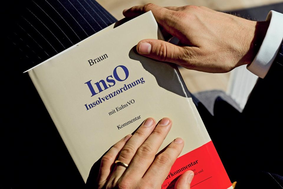 Hände liegen auf der Insolvenzordnung