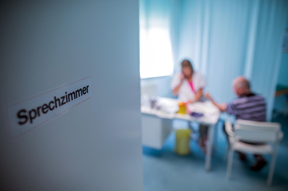 Eine Krankenschwester nimmt einem Patienten Blut ab