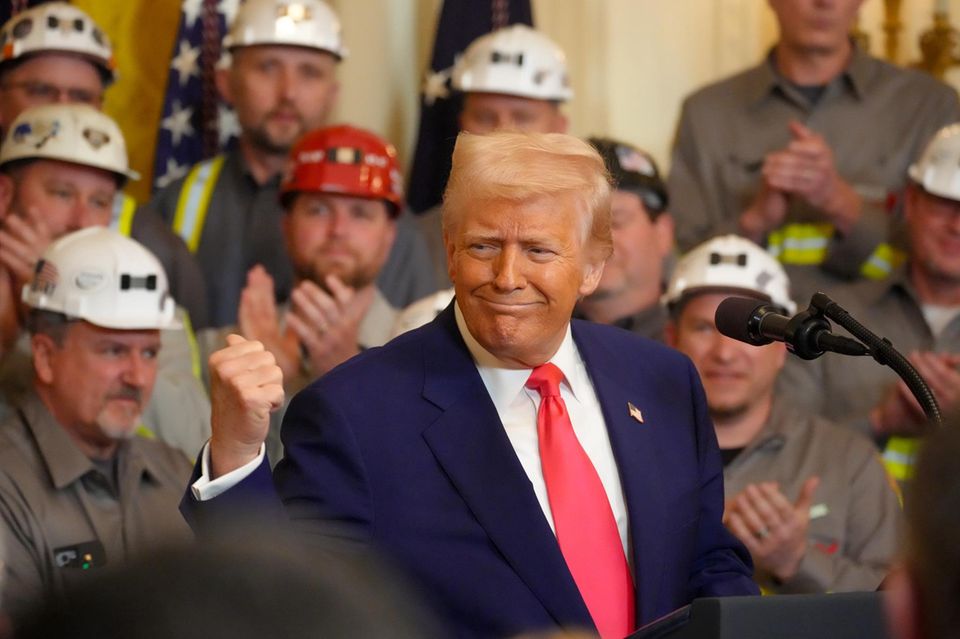 Donald Trump steht im Weißen Haus vor eine Reiher von Bergarbeitern