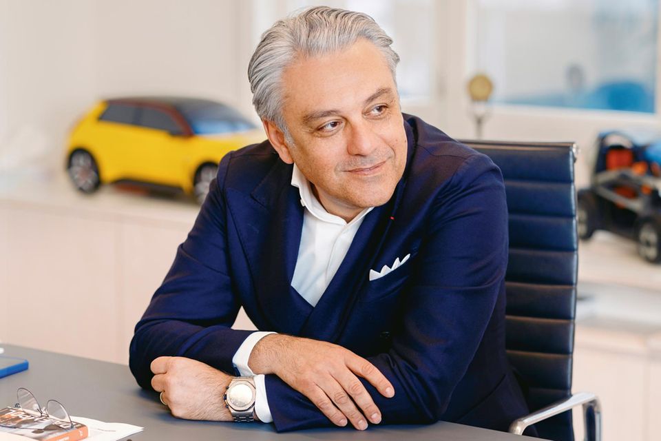Luca de Meo sitzt in seinem Büro amm Schreibtisch
