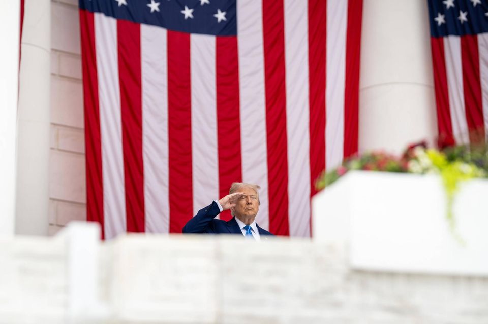 US-Präsident Donald Trump salutiert beim Memorial Day vor einer riesigen US-Fahne