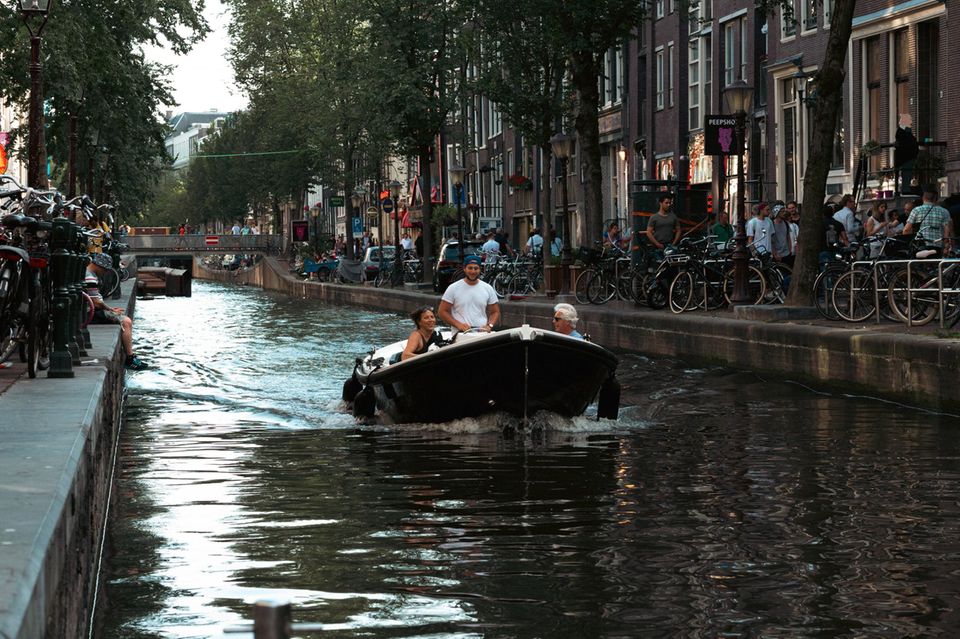 Menschen auf einem Boot in der Gracht von Amsterdam