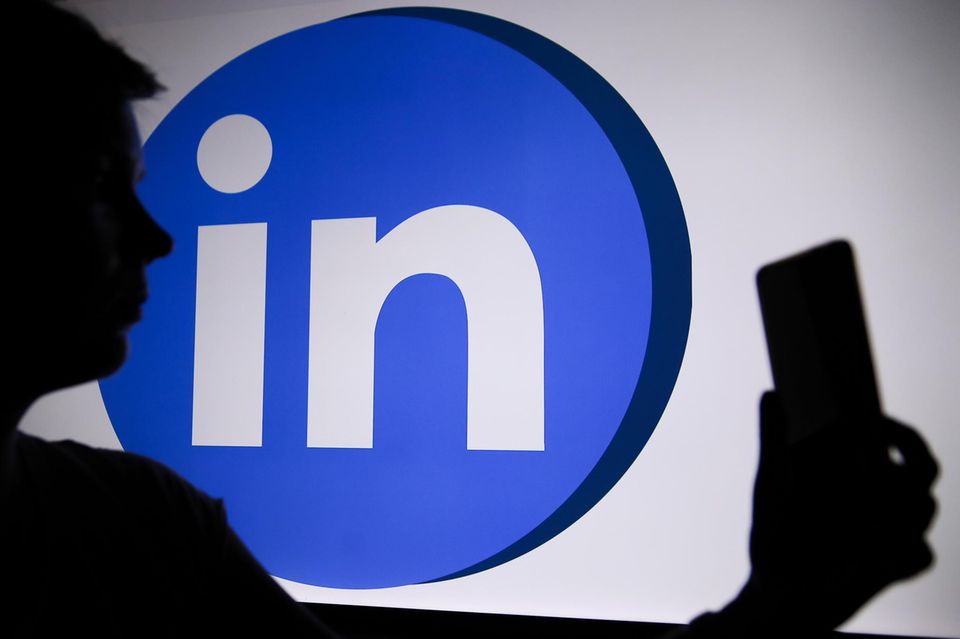 LinkedIn-logo met een persoon die een telefoon vasthoudt