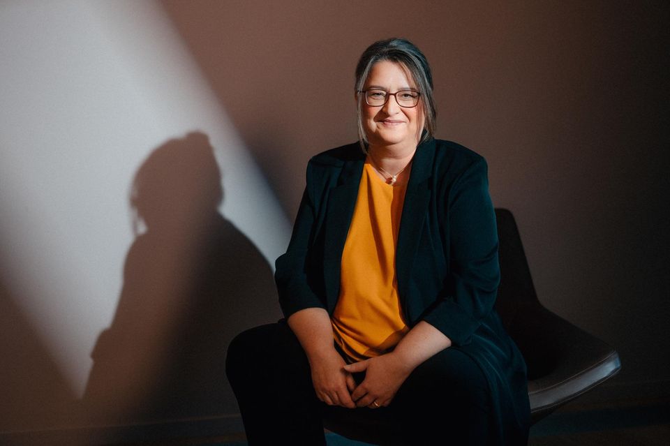 Otto CEO Petra Scharner-Wolff sits on a chair. Her shadow can be seen on the wall.