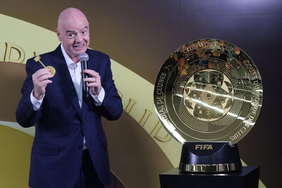 Gianni Infantino stoi obok złotego trofeum Klubowych Mistrzostw Świata FIFA