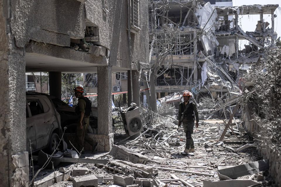 Reddingswerkers bezoeken gebouwen nabij Tel Aviv die verwoest zijn door raketten uit Iran