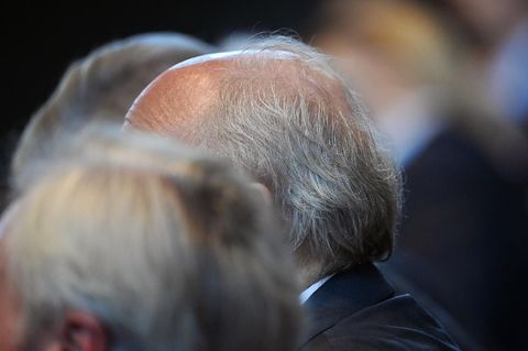 Der grauhaarige Kopf eines Rentners ist in einer Menge zu sehen