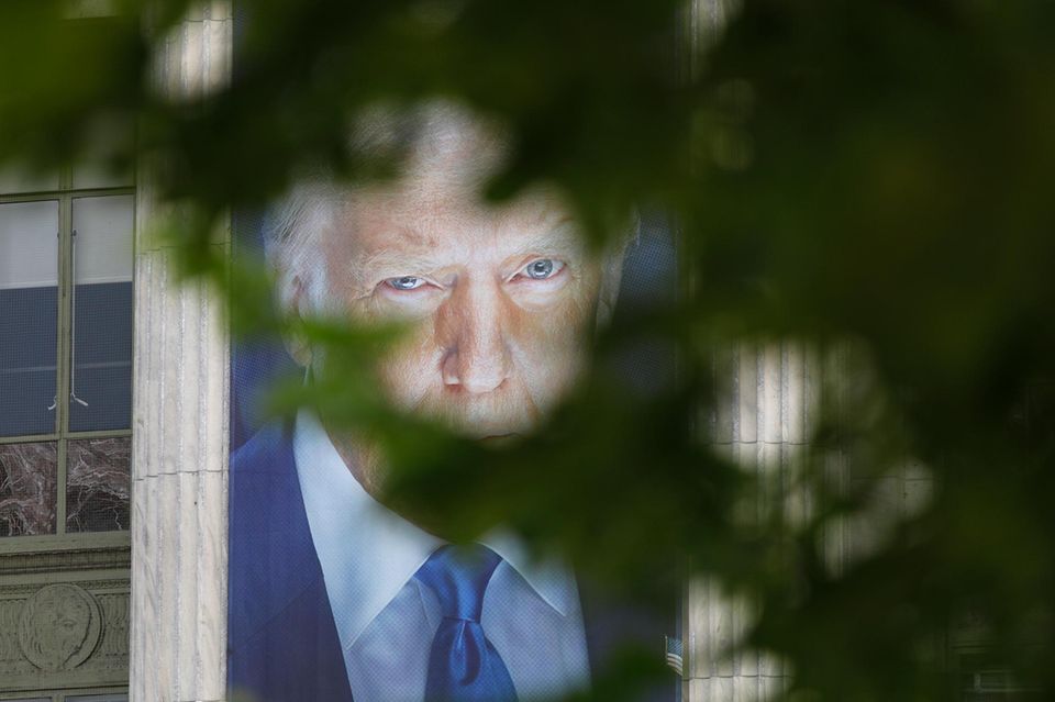 Pôster de Donald Trump fotografado através de uma árvore