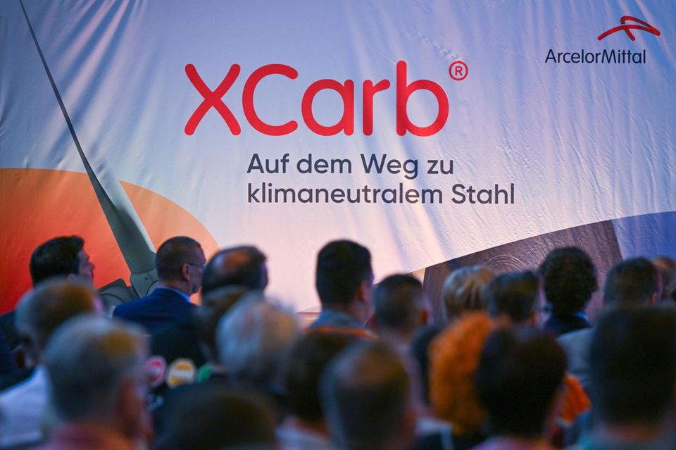 Mitarbeiter von ArcelorMittal nehmen an der Übergabe des Fördermittelbescheides teil