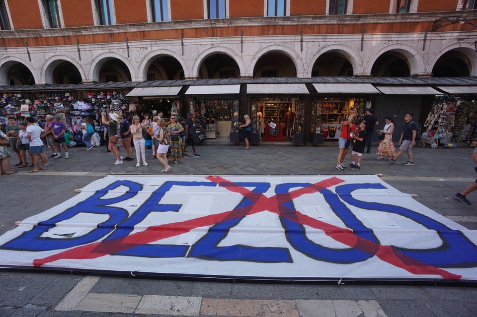 Ein Banner mit dem Namen Bezos, der durchgestrichen ist, liegt auf einem Platz in Venedig