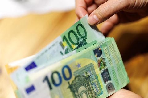 Eine Frau zählt Euro-Geldscheine ab