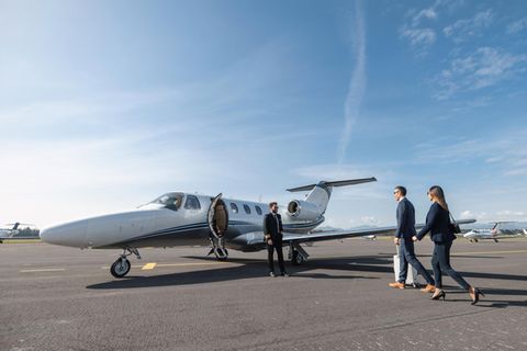 Eine Frau und ein Mann gehen zu einem Privatjet