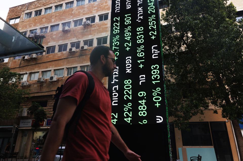 Ein Mann geht an einer Kurstafel der Börse in Tel Aviv vorbei