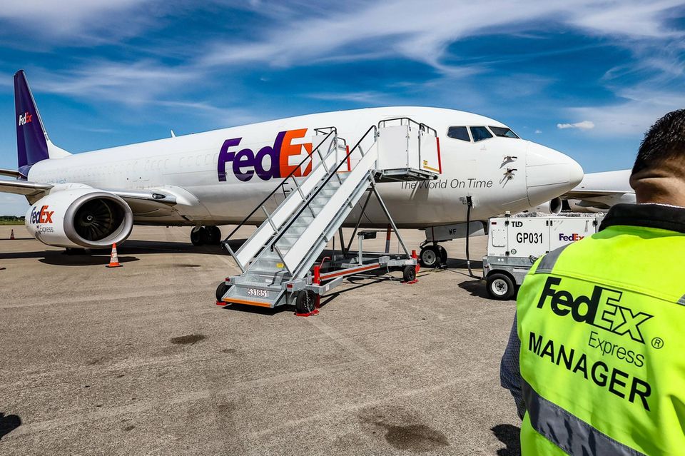 Ein Fedex steht vor einem Flugzeug des Unternehmens