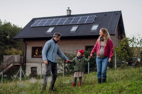 Familie vor Haus mit Solaranlage