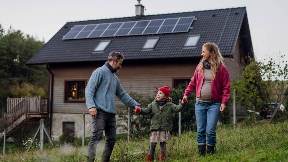 Familie vor Haus mit Solaranlage