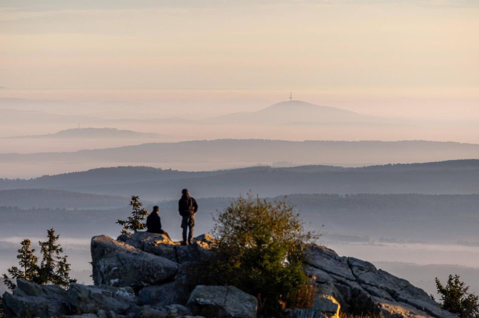 Menschen schauen vom Großen Feldberg aus auf den Nebel im Tal