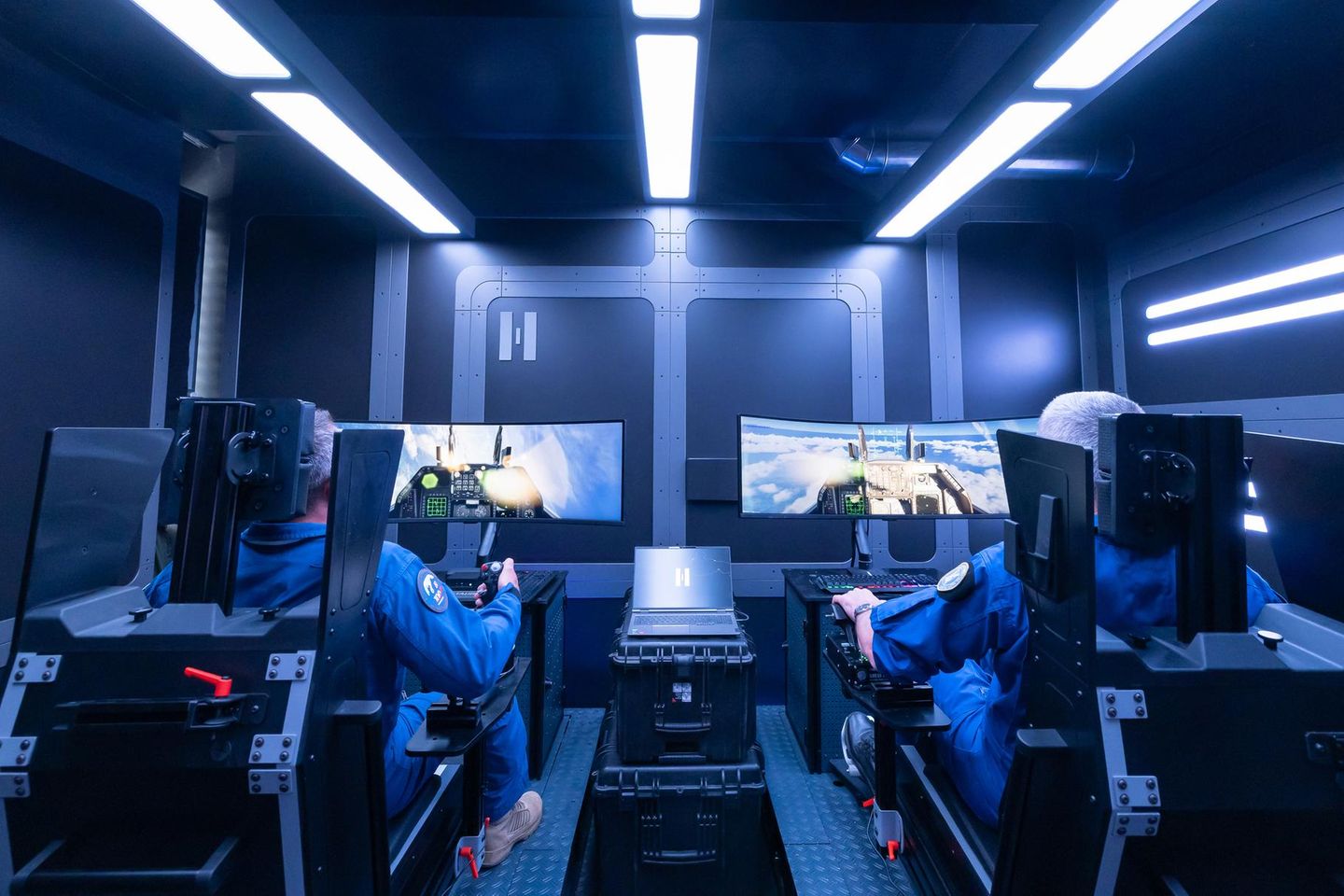 Zwei Helsing-Kampfpiloten sitzen am Flugsimulator in einem futuristisch gestalteten Raum