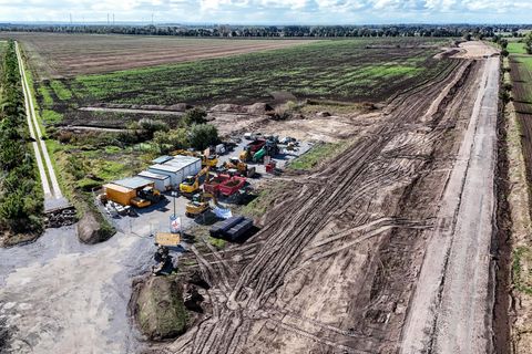 Baufahrzeuge stehen an einer im Bau befindlichen Zufahrtsstraße zum Hightech-Park am Gelände der geplanten Intel Chipfabrik