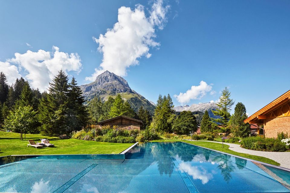 Im Pool des familiengeführten Fünf-Sterne-Hotels „Post Lech“ versüßt der Bergblick jede Bahn