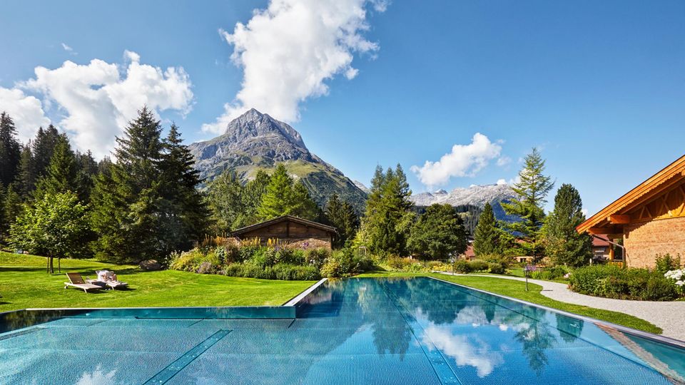 Im Pool des familiengeführten Fünf-Sterne-Hotels „Post Lech“ versüßt der Bergblick jede Bahn