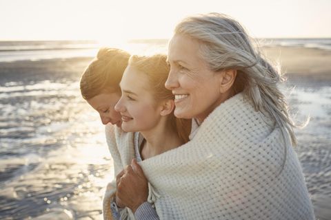Mutter, Tochter, Großmutter stehen am Strand – gemeinsam eingewickelt in ein Tuch ist auch die Mütterrente ein Thema