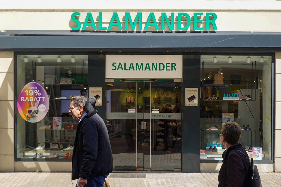 Menschen gehen an einem Salamander-Geschäft in Regensburg vorbei