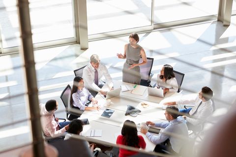 Eine Frau spricht bei einem Meeting mit Mitarbeitern