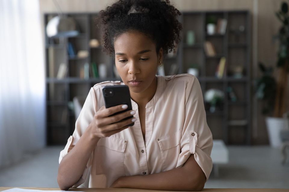 Job: Frau sitzt vor Handy