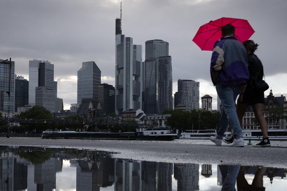 Zwei Menschen mit Regenschirm vor der Frankfurter Skyline