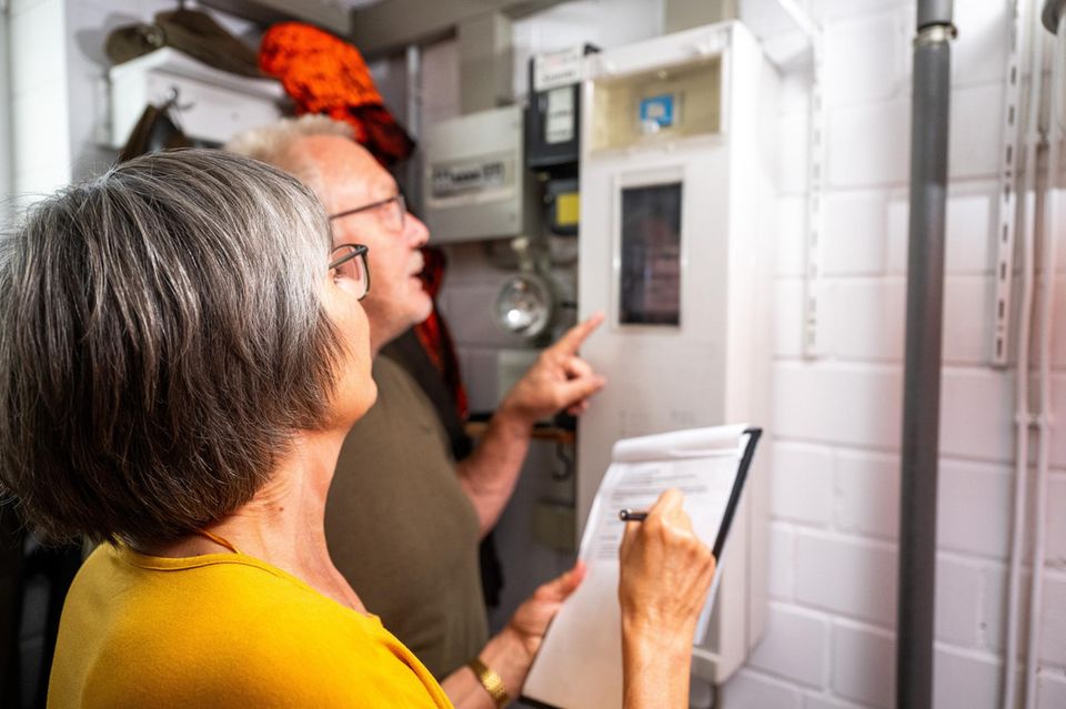 Yaşlı bir çift elektrik sayacının önünde duruyor