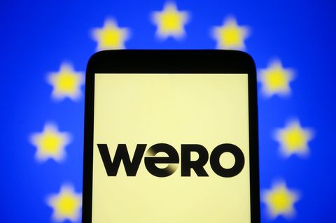 Ein Smartphone mit Wero-Logo vor europäischer Fahne