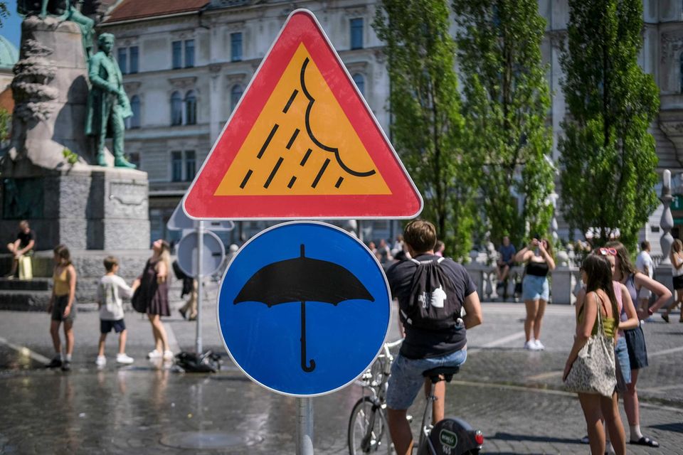 Schilder weisen auf Wasserfontänen hin, die auf dem Preserenplatz wegen hoher Temperaturen zur Abkühlung aufgestellt sind