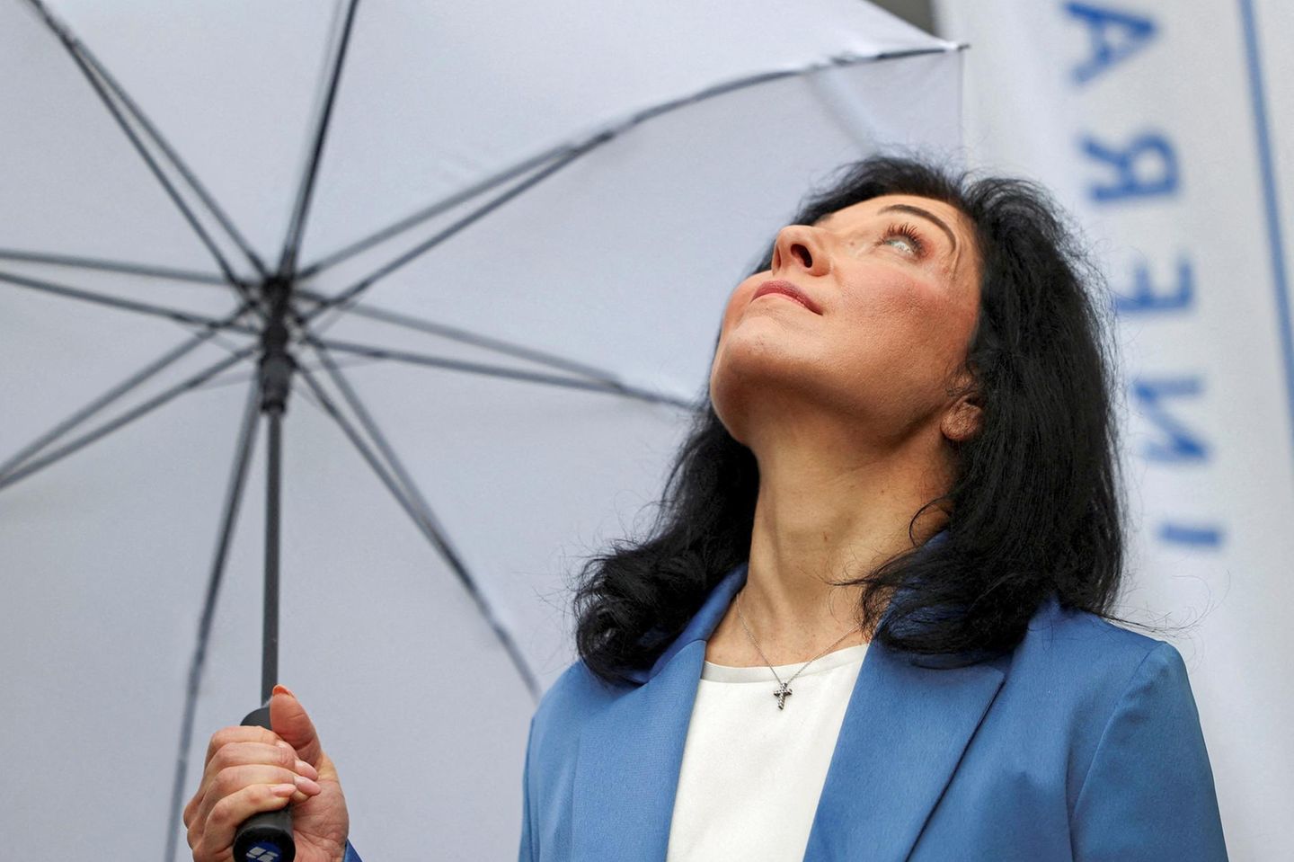 Katherina Reiche hält einen Schirm und blickt nach oben