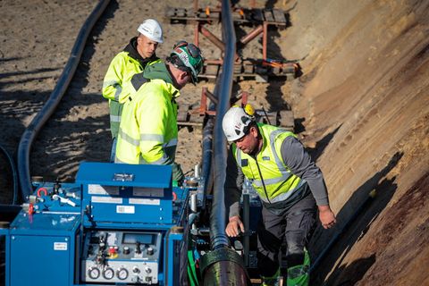 Arbeiter verlegen auf einer Baustelle von Tennet-SuedLink eine Erdkabelverbindung