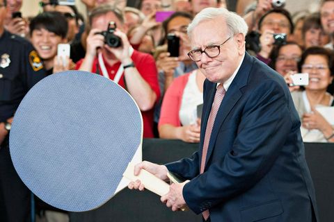 Warren Buffett hält einen riesigen Tischtennisschläger in der Hand