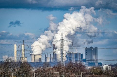 Dampf steigt aus den Kühltürmen des Braunkohlekraftwerks Niederaußem auf