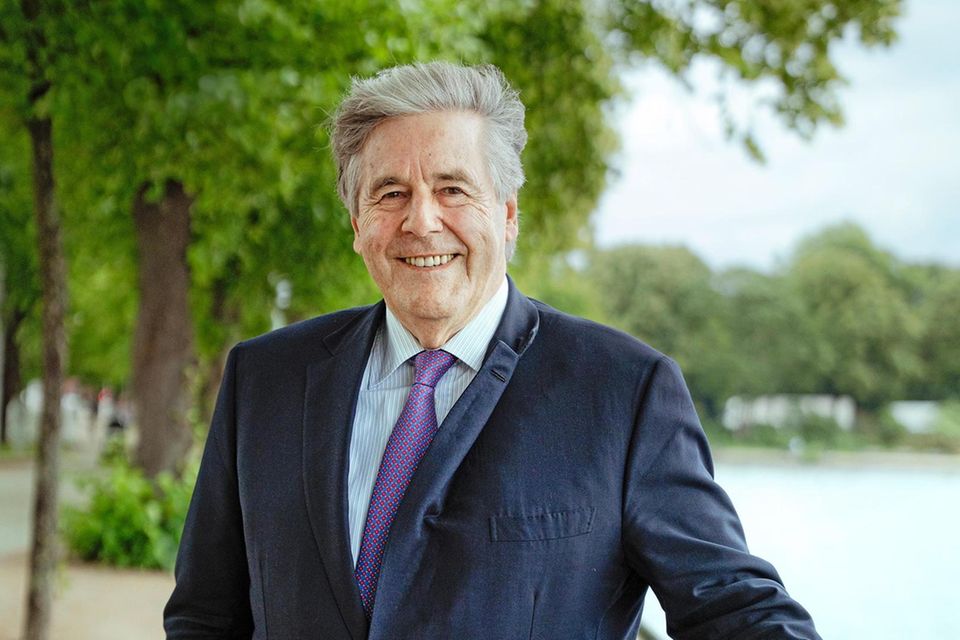 Josef Ackermann mit werwehtem Haar bei einem Besuch in Hamburg an der Alster