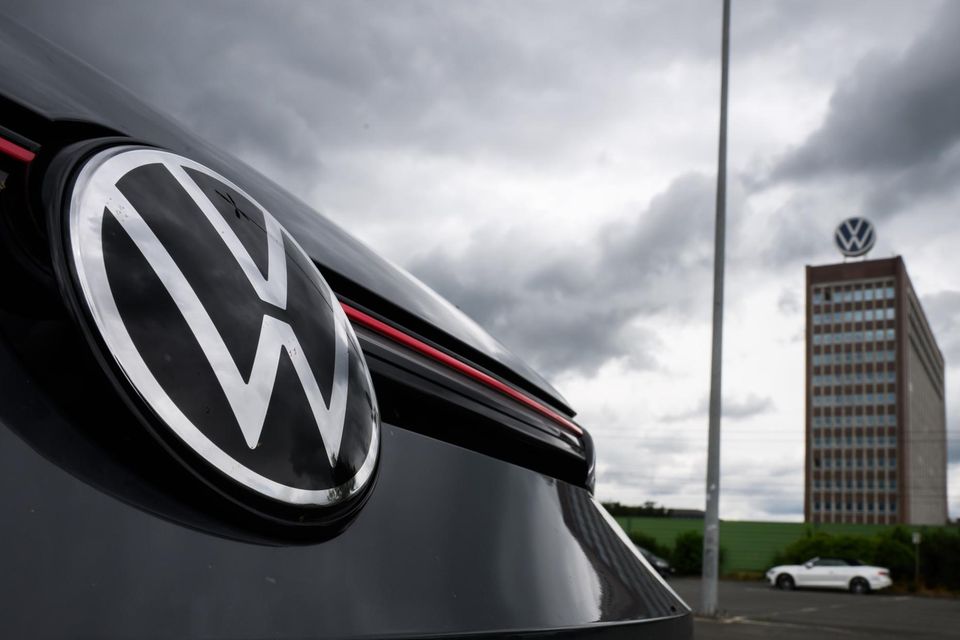 Ein VW Golf GTI steht auf einem Parkplatz in Sichtweite vom Markenhochhaus auf dem Gelände vom VW Werk Wolfsburg