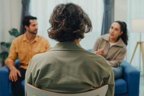 Eine Mediatorin sitzt einem Mann und einer Frau gegenüber