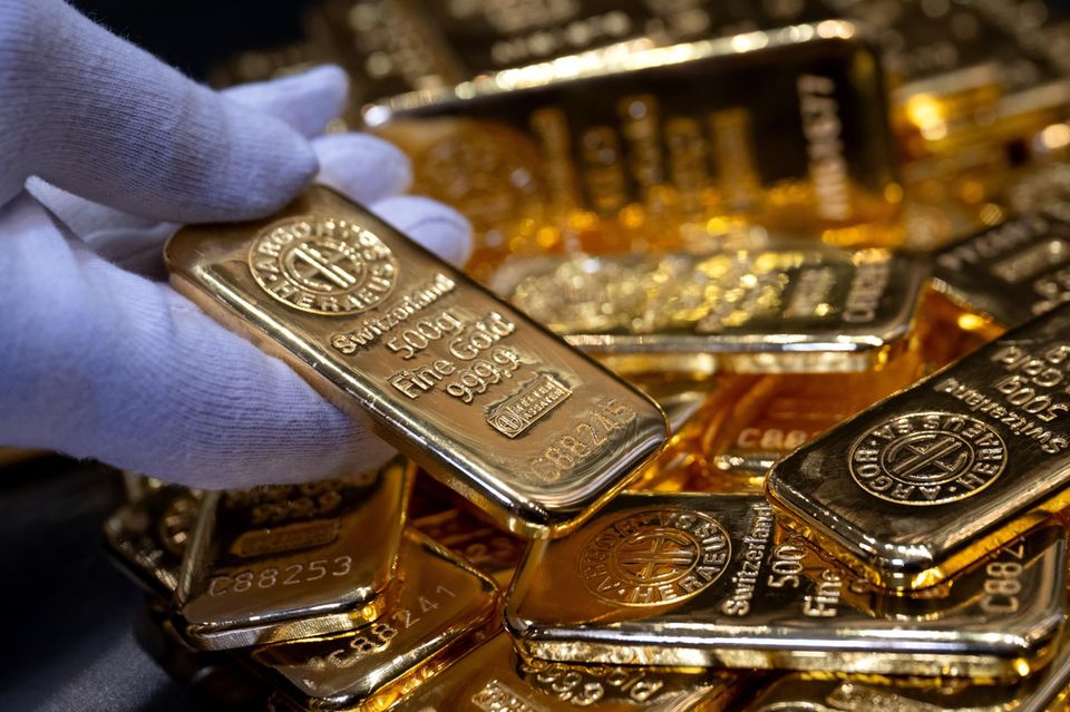 Eine Person hält einen kleinen Goldbarren in der Hand